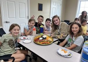 One of last year's student volunteers Josie Carter and her team pose with their charcuterie board.